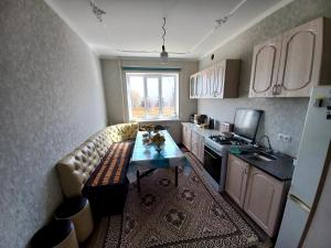a kitchen with a couch and a table in it at Beksultan guest house in Epkin