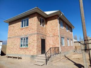 a red brick building with a black door and stairs at Beksultan guest house in Epkin