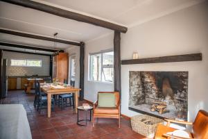 a living room with a table and a fireplace at Stayatdestraadt Red Fin Cottage in Op-die-Berg
