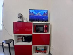 a tv sitting on top of a red cabinet at Appartamento Vale in Viareggio