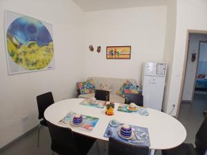 a kitchen with a table and a white table and a couch at Appartamento Vale in Viareggio