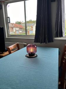 a candle on a table in a room with a window at Gîte Le Sambre in Thuin