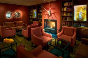 a waiting room with red chairs and a fireplace at Naturresort & Spa Schindelbruch in Stolberg +79 photos