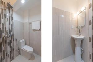 Un baño blanco con inodoro y lavabo. en OYO 729 Hotel Era, en Bālāju 17 fotos más