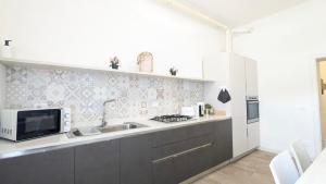 a kitchen with a sink and a microwave at VivimiHome - Oasi Verona spazio comfort e relax in Verona