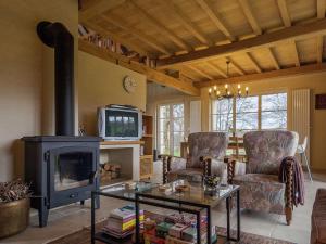 a living room with a fireplace and a tv at Modern and comfortable home with swimming pool in Dezéjoul