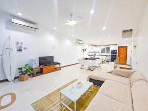 a living room with a couch and a pool table at Surf Villa Bangsaray in Bang Sare