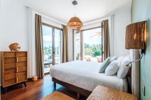 a bedroom with a bed and a large window at Luxury Boutique B&B - Villa Prana Marbella in Ojén