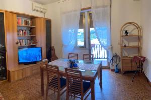a living room with a dining room table and a television at A Casa Mia in Albano Laziale