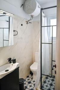 a bathroom with a toilet and a sink and a shower at Ikaria Studios in Agios Kirykos