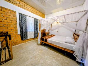 a bedroom with a canopy bed and a brick wall at purple villa in Mirissa