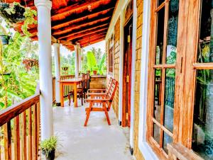 a porch with chairs and a table on a house at purple villa in Mirissa