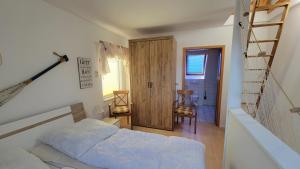 a bedroom with a bed and a ladder and a door at Ferienwohnung Ankerplatz Thiessow in Thiessow