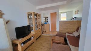 a living room with a couch and a television at Ferienwohnung Ankerplatz Thiessow in Thiessow