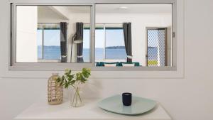 a bathroom with a mirror and a table with a plate at Waterfront Cottage in New South Wales 