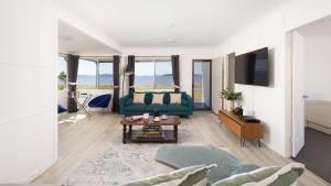 un salon avec un canapé et une table dans l'établissement Waterfront Cottage, à New South Wales 