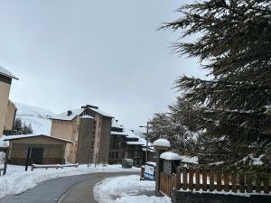 a snow covered street with buildings and a fence at Nevada suites Dúplex con vistas y acceso a pista in Sierra Nevada