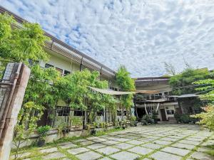 een gebouw met veel bomen ervoor bij RedDoorz near KCC Mall Gensan in General Santos