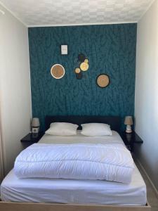 a bedroom with a large bed with a green wall at Les volets verts in Le Crotoy