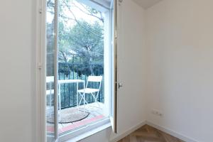 a room with a window and a chair on a balcony at La Cayon Au coeur des oliviers en Provence in Pélissanne