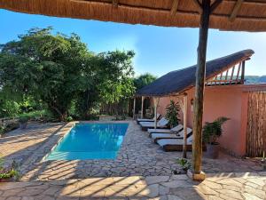 a villa with a swimming pool and a house at Kikonko Lodge in Biseruka