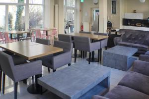 a restaurant with tables and chairs and tables andwindows at Nu Wave Hotel Berlin - Digital Check-In in Berlin