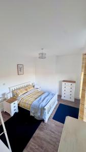 a bedroom with a bed and a dresser at The Follonsby hot tub Retreat with own bar near city centre in Gateshead