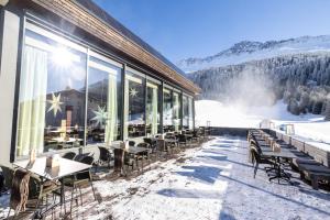 een restaurant met tafels en stoelen in de sneeuw bij Valbella Resort in Valbella