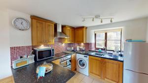 Saddle Cottage في بينزانس: مطبخ مع حوض وثلاجة