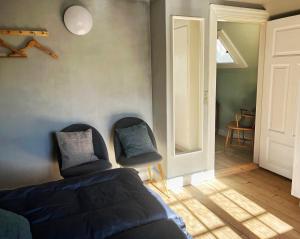 a bedroom with two chairs and a bed and a door at Brakilde B&B in Stege +34 photos