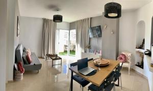 ein Wohnzimmer mit einem Tisch und einem Laptop darauf in der Unterkunft The Pradise of Ana Vemar Exclusive Apartament in Playa Paraiso