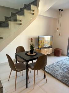 アテネにあるKallitheas Maison with Shared Poolのテーブルと椅子とテレビのあるダイニングルーム