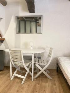a white table and chairs in a room with a bed at Studio terrasse. A 50m de la plage Sablettes in Menton