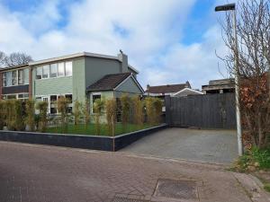 a house with a fence and a driveway at Studio Smidt in Den Burg