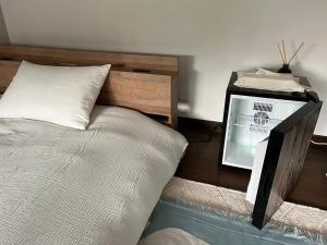 a bedroom with a bed and a night stand with a fan at 泊まれるカフェやわらかそう in Koka