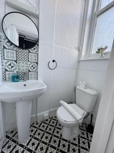 a bathroom with a sink and a toilet and a mirror at Marine Parade Hotel by PLI in Eastbourne +204 photos