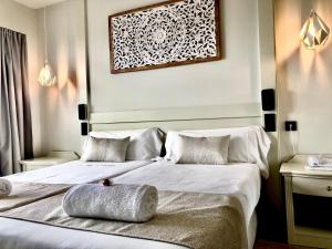 a hotel room with two beds and a picture on the wall at Hotel Ankaa - Adults Only in Porto Cristo