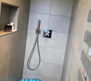 a shower with a hose in a bathroom at Heidequartier Ferienwohnung in Bispingen +10 photos