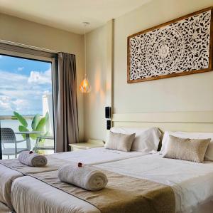 a bedroom with two beds and a large window at Hotel Ankaa - Adults Only in Porto Cristo
