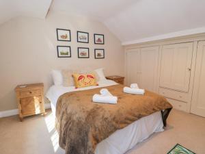 a bedroom with a bed with two towels on it at Glandwr Cottage in Llanbedr