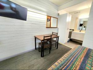 a room with a table and a bed and a sink at Finley Motel in Finley