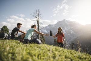 a group of people sitting on top of a hill at Ferien & Wellnesshotel Windschar in Brunico +78 photos