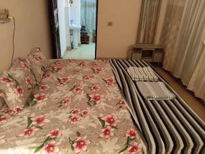 a bed with a blanket with flowers on it at Geeta Villa in Lucknow