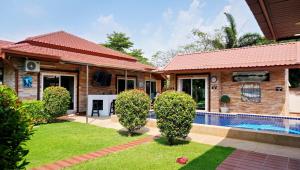 ein Haus mit einem Swimmingpool im Hof in der Unterkunft Luxury 6BHK Villa with Private Pool in Pattaya by - OzyStays in Nong Prue