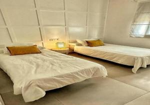 2 camas con sábanas blancas en una habitación en Villa 90 by Villamya, en El Gastor 8 fotos más