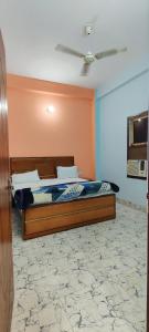 a bedroom with a bed with an orange wall at Geetasheel Palace in Naimishāranya