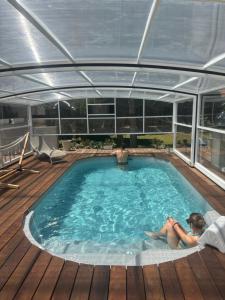 una mujer sentada en una piscina en un yate en La Maison d'hôtes du Chapelier, en Espéraza