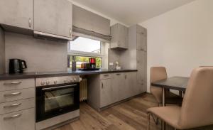 a kitchen with a stove and a table in it at Appartementhaus Bahlo inklusive THERMEplus in Bad Bevensen