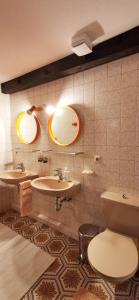 une salle de bain avec deux lavabos et un WC et deux miroirs dans l'établissement Gemütliches Ferienreihenhaus mit Holzkamin im Schwarzwald, à Bernau im Schwarzwald