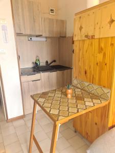 una piccola cucina con un tavolo e un lavandino di Les soleillades - Joli appartement avec piscine a Palavas-les-Flots